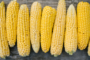 Yellow fresh organic corn, peeled ears on a wooden Board close-up
