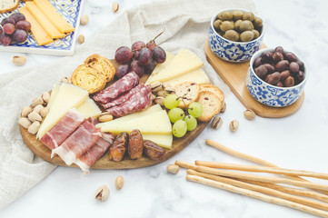 Cheese board brunch with pistachios, olives and grapes