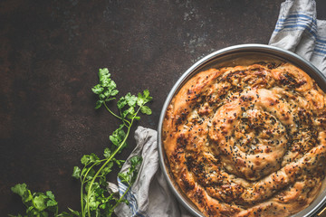 Turkish cuisine. Savory pie with Phyllo dough. Su boregi, burek or borek on dark rustic background. Top view.