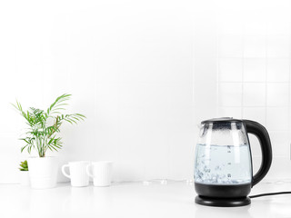 Glass transparent kettle on white kitchen table