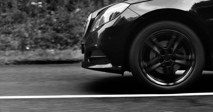 Reflecting everything around with its glossy surface, the premium car rides asphalt road where you can observe the suspension and how the tires perceive driving conditions. Black and white color