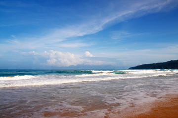 Waves, surf, and the blue sky over the sea, Karon sandy beach on a sunny day, Thailand