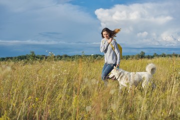 Dynamic outdoor portrait of running girl with dog