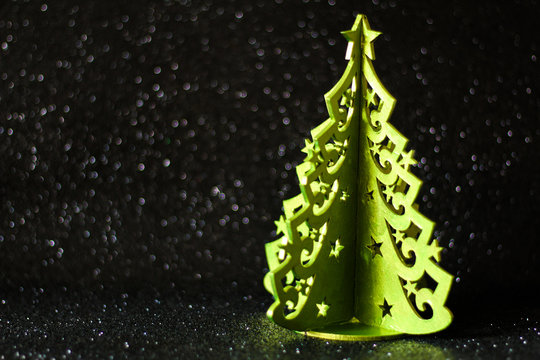Simple Christmas concept: 3d christmas tree, selective focus, black glitter background, free copy space
