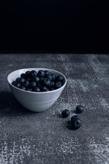 A bowl of blueberries on a rustic surface