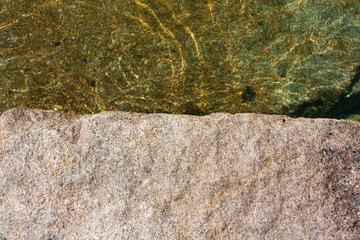 stone texture and clear water. stone surface at the edge of water.