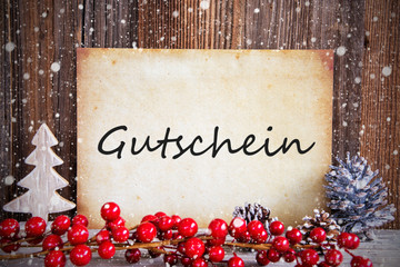 Fototapeta na wymiar Paper With German Text Gutschein Means Voucher. Christmas Decoration And Wooden Background With Snow