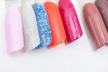 A palette of nail designs of different colors with gel polish on a white background. A collection of testers for nail polish.