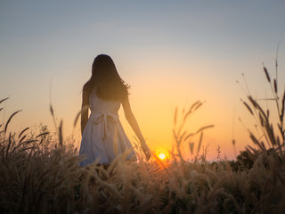 Trendy girl in stylish summer dress feeling free in the field with flowers in sunshine,enjoying...