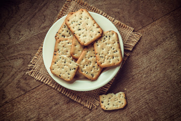 Closeup of black sesame crackers on white plate. Closeup of snacks plate.