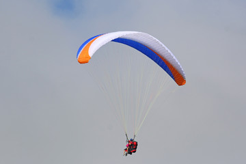 Tandem Paraglider flying wing in a blue sky	
