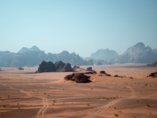 Tyre tracks in the desert of Wadi Rum with mountains in the background