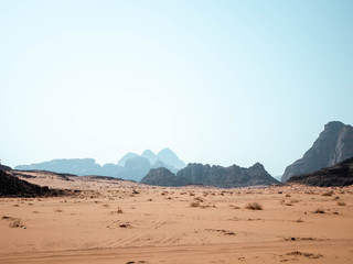 Rocky outcrops in the desert of Wadi Rum with mountains in the background