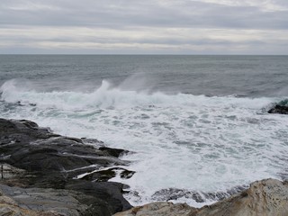 Waves breaking and rolling toward the rocky shores of a coastal area