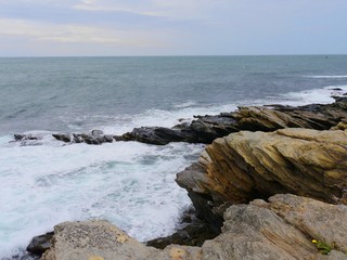 Fototapeta na wymiar Colored limestones and rocks in a tiny cove of a coastal area