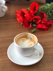 cup of coffee and flowers on table