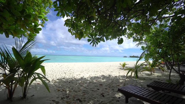 Camera is moving from beach to blue lagoon in Maldives 4K