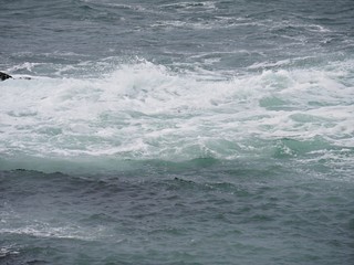 Wide shot of waves breaking on the rocky shores of a beach