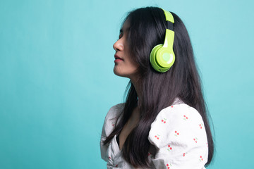 Pretty asian girl listening music with her headphones.