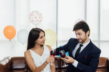 Young couple celebrating new year together, drinking wine together.