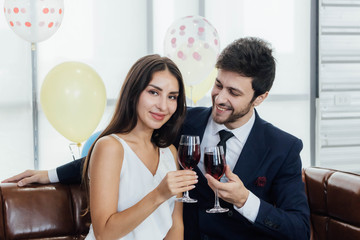 Young couple celebrating new year together, drinking wine together.