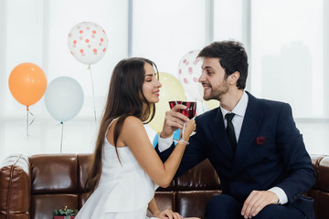 Young couple celebrating new year together, drinking wine together.