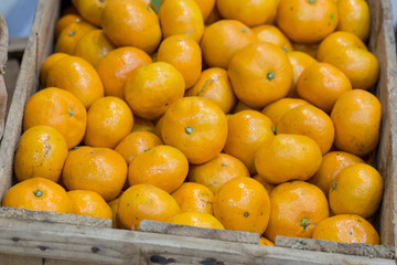 bunch of fresh tangerines in a wooden box