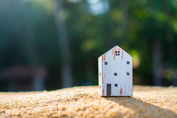 Closed up tiny home model on green grass with sunlight background.