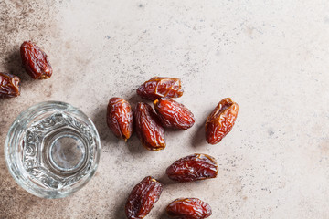 Dates and glass of water, copy space. Iftar food concept.
