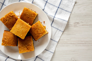 Homemade Sliced Cornbread Ready to Eat on a white plate, top view. Flat lay, overhead, from above. Copy space.