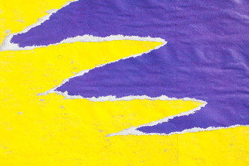 Yellow and purple old crumpled, torn and peeling paper placards texture background.