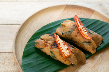 Grilled fish with curry paste and coconut milk on banana leaf in wooden dish,Thai food.