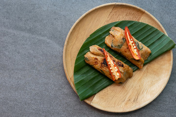 Grilled fish with curry paste and coconut milk on banana leaf in wooden dish,Thai food.
