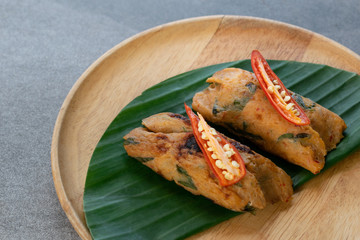 Grilled fish with curry paste and coconut milk on banana leaf in wooden dish,Thai food.