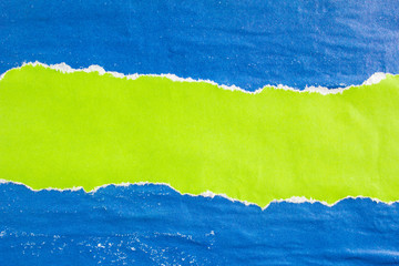 Blue and green crumpled, torn and shabby old gloss paper posters and placards on rough surface...