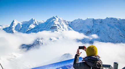 woman traveler in Swiss alps Jungfrau region taking pictures