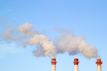 Smoking industrial stacks in a thermal power plant emit polluted air into the atmosphere in the...