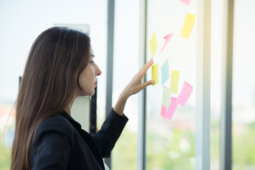 Businesswoman working in office in action thinking with sticky note to do list  using as background professional business people, successful business woman consultant concept.