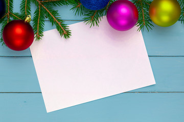 Christmas background, green fir branches, red and blue, pink, yellow, ball, white sheet, blue boards, frame pattern
