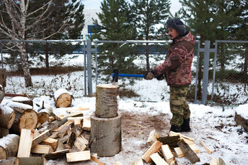 Man chopping wood in the winter.