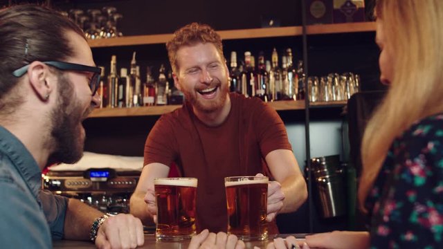 Cheerful caucasian bartender serving customers. Pub interior.