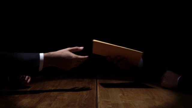 Businessman giving bribe money in the envelope to partner
