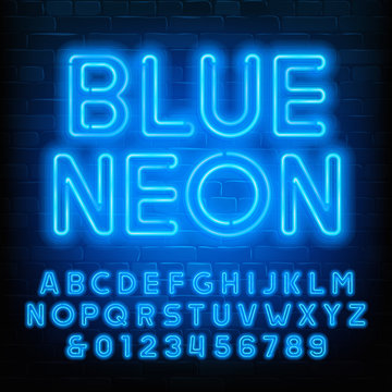 Blue Neon alphabet font. Uppercase neon light letters and numbers. Brick wall background. Stock vector typescript for your typography design.