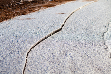 Fototapeta na wymiar Sandy beach in winter, snow and ice on the river bank.