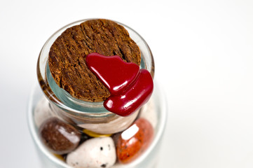 Glass jar with sweets closed by a cork and sealed with red wax