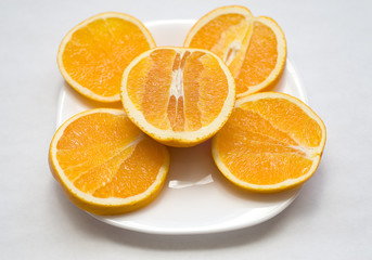 cut orange lies on a white plate