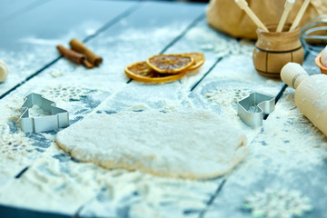 Christmas baking background. Raw dough for Christmas cookies. Kitchen utensils and ingredients for...