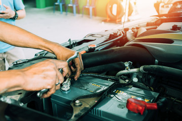 Fototapeta na wymiar Mechanic using tools for changing the car battery. Car repair service.