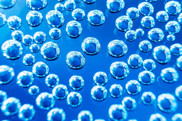 Bubbles of mineral water close-up. Macro photo in blue shades. Background stylish image, minimalism.