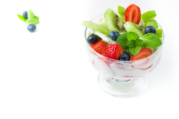 Bowl of homemade granola with yogurt and fresh berries: strawberry, kiwi and blueberry on white  background  from side view. Copyspace